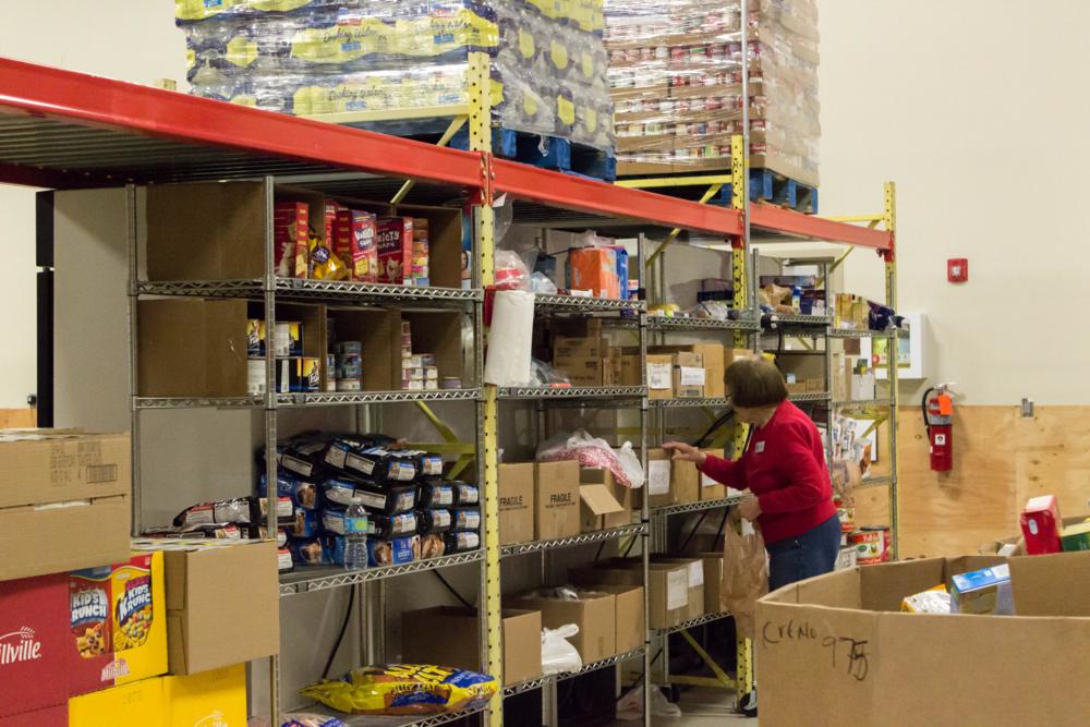 Emergency Food Pantry Volunteer. Stacking shelves with food. 